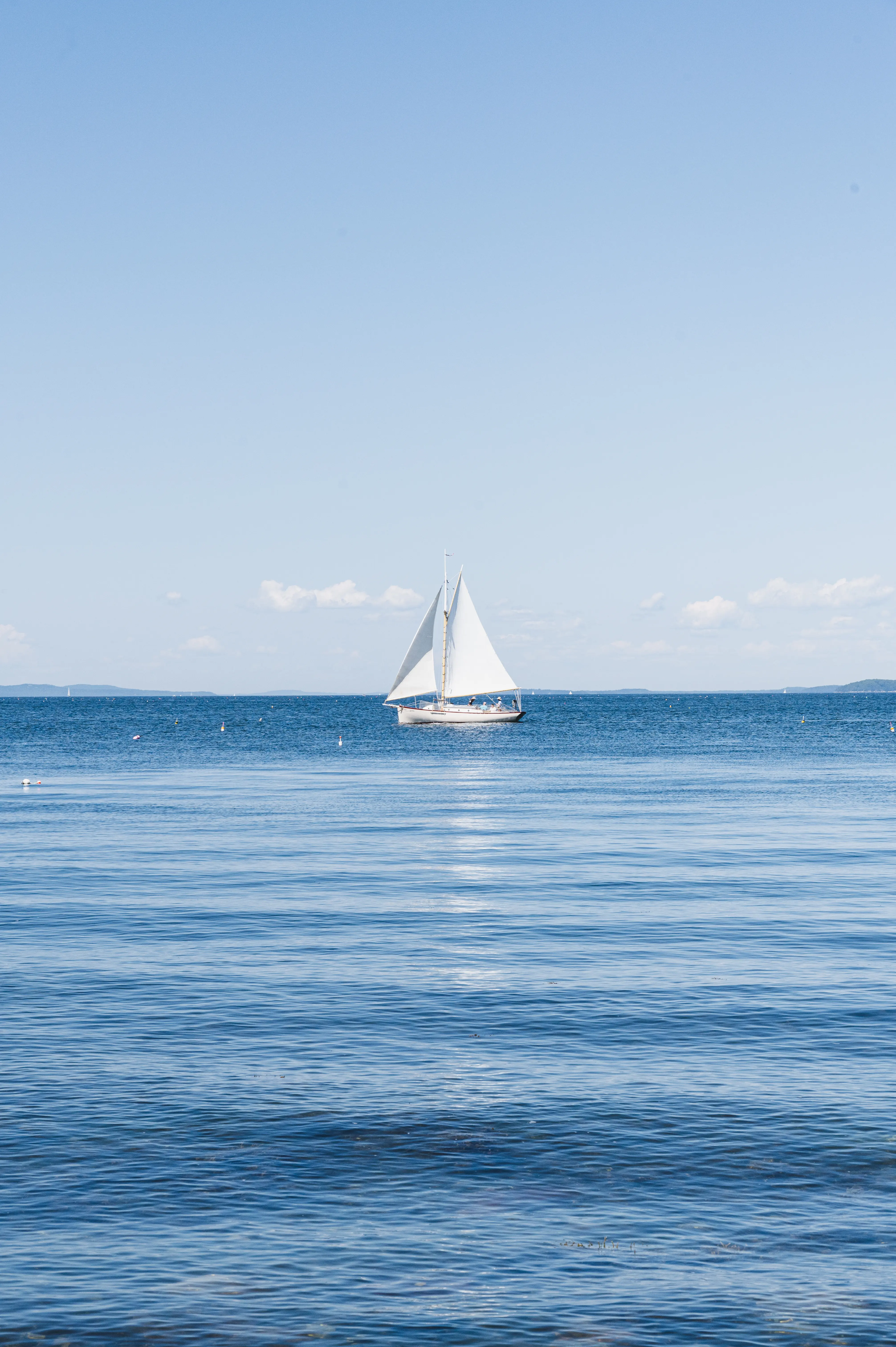 a sailboat floats on the open ocean